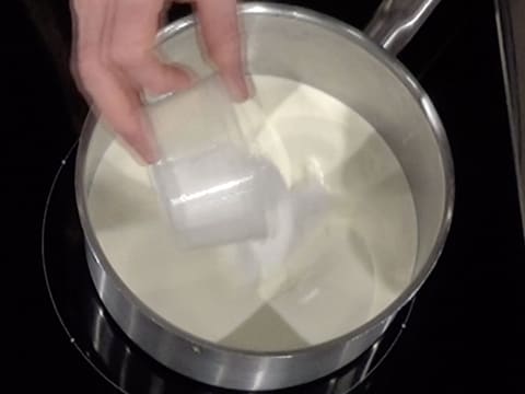 Ajout du sucre en poudre dans le lait et la crème, dans la casserole