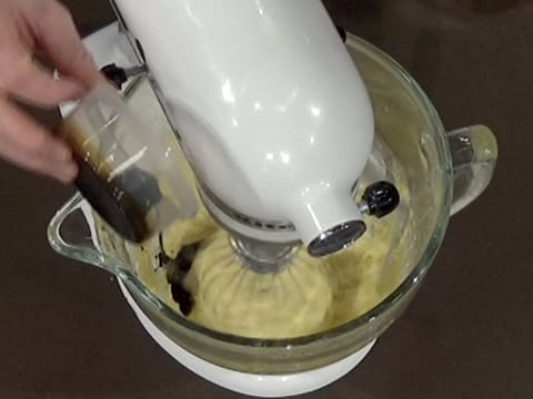 Ajout de l'extrait de café liquide dans la crème pâtissière, dans la cuve du batteur