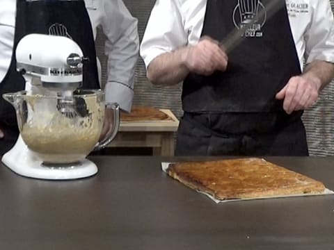 Une plaque de pâte feuilletée cuite est placée sur le plan de travail