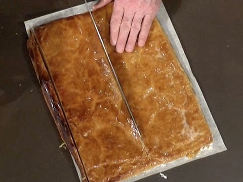 La pâte feuilletée cuite est coupée en deux dans le sens de la longueur