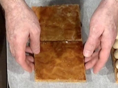 Les deux chutes de pâte feuilletée cuite sont rassemblées sur la plaque à pâtisserie recouverte de papier sulfurisé