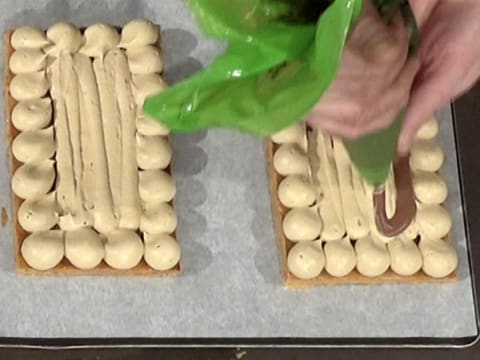 Le crémeux chocolat est poché au centre de la bande de pâte feuilletée, sur la mousseline café