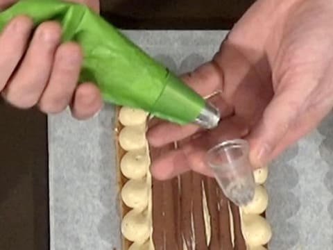 Une douille cannelée est emboîtée dans la douille unie de la poche à douille contenant la crème mousseline café