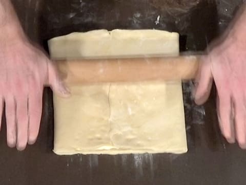 Le pâton est abaissé sur la longueur à l'aide du rouleau à pâtisserie