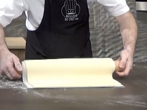 La pâte feuilletée est déroulée sur une plaque à pâtisserie