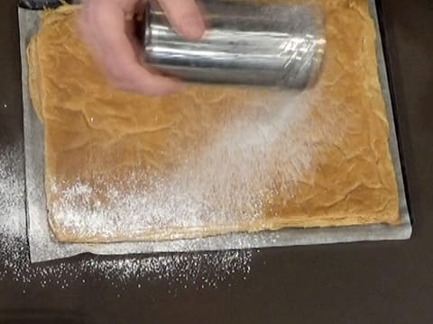 La pâte feuilletée est saupoudrée de sucre glace