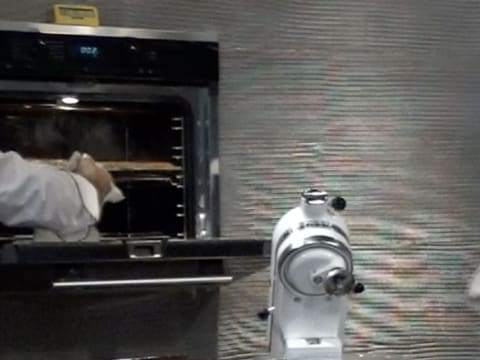 La porte du four est ouverte pour surveiller la cuisson de la pâte feuilletée