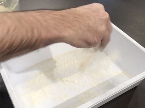 Saupoudrage de farine dans un bac