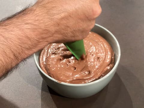 La mousse au chocolat noir est pochée dans le grand bol à la poche pâtissière