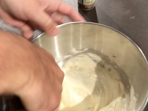 Mélange de la pâte à génoise vanillée dans la cuve du batteur, à l'aide de la spatule maryse