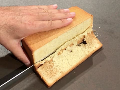 La génoise vanillée est parée sur un côté, à l'aide d'un couteau-scie à génoise
