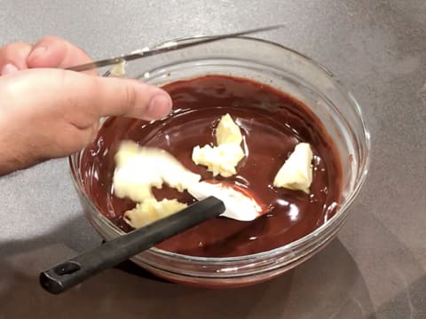 Ajout du beurre pommade coupé en morceaux dans la préparation chocolatée