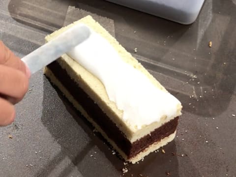 Le glaçage au sucre est étalé sur toute la surface du gâteau avec une mini spatule métallique coudée