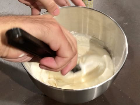 La farine est incorporée dans la préparation mousseuse à l'aide de la spatule maryse