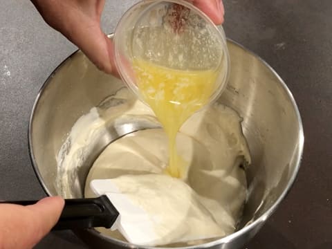 Ajout du beurre fondu dans la préparation mousseuse dans la cuve du batteur