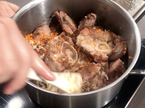 La viande, l'oignon ciselé et la brunoise de carotte sont mélangés à l'aide d'une spatule dans le faitout