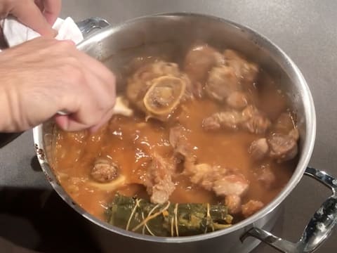 Mélange de l'osso buco dans le faitout à l'aide d'une spatule