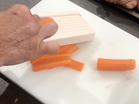 Les carottes sont émincées en fines tranches à l'aide d'une mandoline
