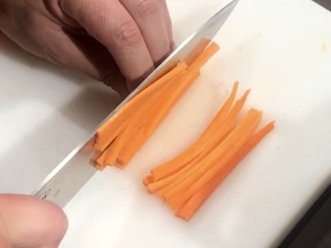 Les carottes sont émincées en julienne à l'aide d'un couteau sur une planche à découper