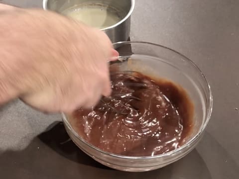 Mélange au fouet de la préparation chocolatée dans le saladier en verre