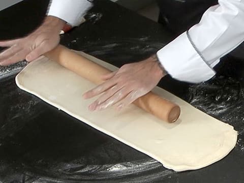 Le rouleau à pâtisserie est passé sur les angles de la pâte et aplatit ces derniers