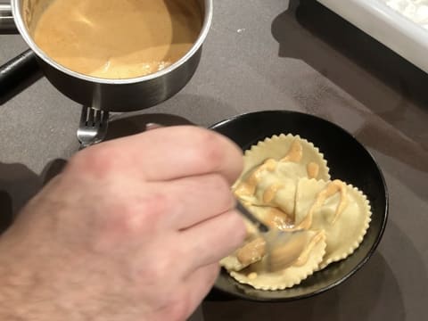 Sauce versée sur ravioles