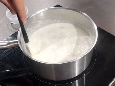 Le lait qui contient le sucre en poudre, la vanille et le riz rond est en train de frémir dans la casserole, tout en étant mélangé avec la spatule maryse