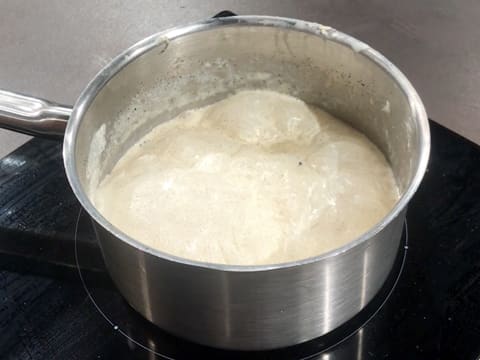 Le riz rond est en train de cuire dans le lait qui est en petite ébullition dans la casserole