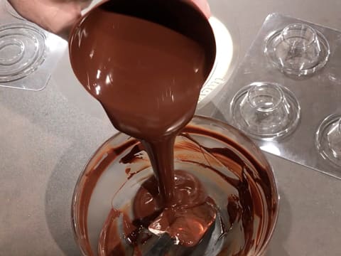 Le chocolat fondu contenu dans le moule est vidé dans le saladier