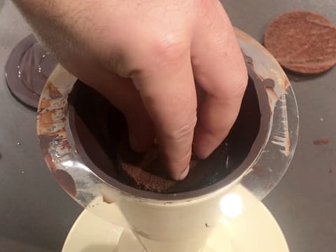 Un disque de biscuit chocolat est déposé sur le confit de griotte