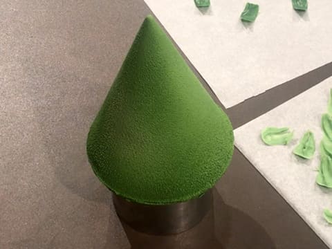 Le sapin en chocolat vert est placé sur un cercle inox