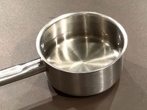La casserole contenant l'eau et le sucre fondu est retirée du feu