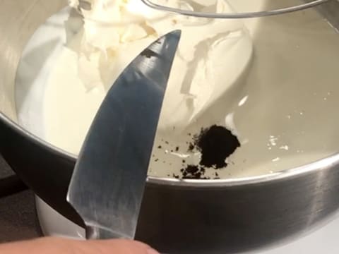 Ajout d'une pointe de couteau de vanille en poudre dans la crème liquide