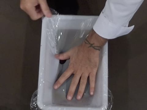 Le confit à la myrtille qui est dans le bac alimentaire, est filmé au contact avec une feuille de papier film