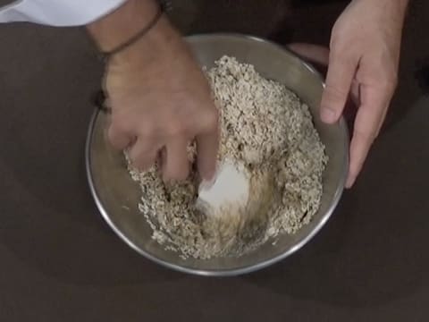 Mélange des flocons d'avoine avec le beurre de cacahuètes et le sirop à 16° baumé avec la spatule maryse, dans le cul de poule