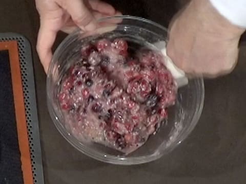 Mélange de la préparation aux amandes avec les fruits rouges dans le saladier, à l'aide de la spatule maryse