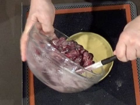 La préparation aux amandes et aux fruits rouges est versée sur le fond de pâte sablée qui se trouve sur la toile de cuisson en silicone