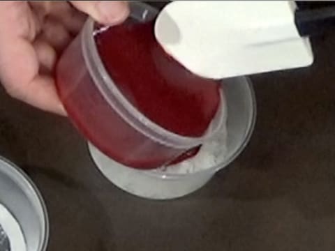 Un peu de purée de fruits rouges est versé dans la masse de gélatine hydratée