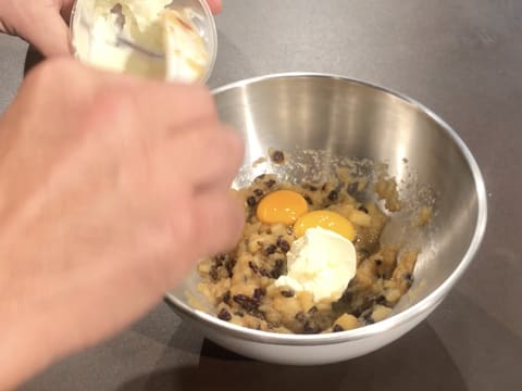 Ajout de la crème fraîche épaisse sur la compote de pommes et les deux jaunes d'oeufs dans le cul de poule