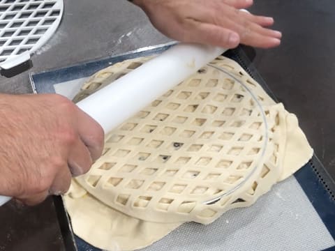 Le décor en pâte feuilletée grillagée est soudé au fond de pâte avec le rouleau à pâtisserie qui écrase les bords