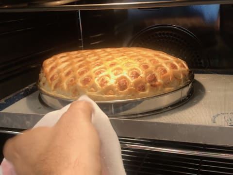 La tarte normande qui est cuite, gonflée et dorée, est retirée du four