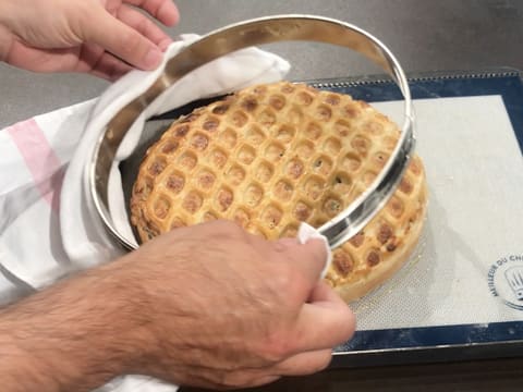 Le cercle à tarte en inox est retiré de la tarte normande vers le haut et avec un torchon