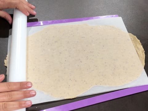 La pâte sucrée noisette est étalée au rouleau à pâtisserie entre deux réglettes à niveler