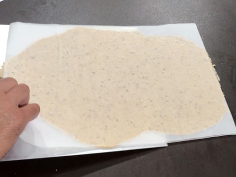 La pâte qui est entre les deux feuilles de papier sulfurisé, est placée sur une plaque à pâtisserie