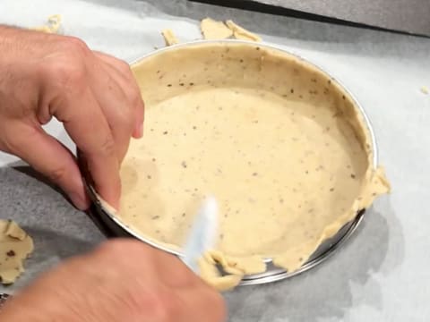 L'excédent de pâte qui est foncé dans le cercle inox, est retiré avec la lame d'un couteau