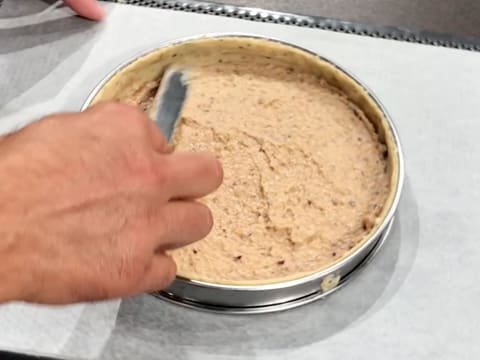 La crème de noisettes est étalée sur le fond de pâte crue à l'aide d'une petite spatule coudée