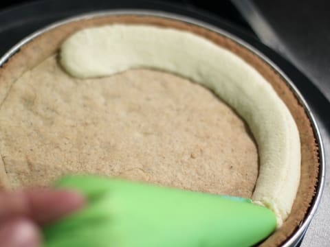 La crème d'amandes est pochée sur le fond de pâte sablée à la noisette