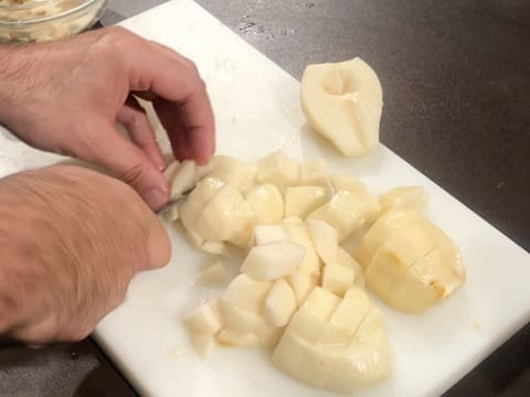 Les poires sont coupées en gros morceaux à l'aide d'un couteau sur la planche à découper