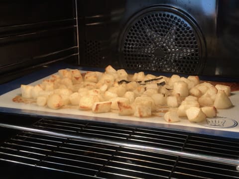 Les morceaux de poires enrobés de beurre et de sucre fondus sont caramélisés sur le tapis de cuisson en silicone dans le four