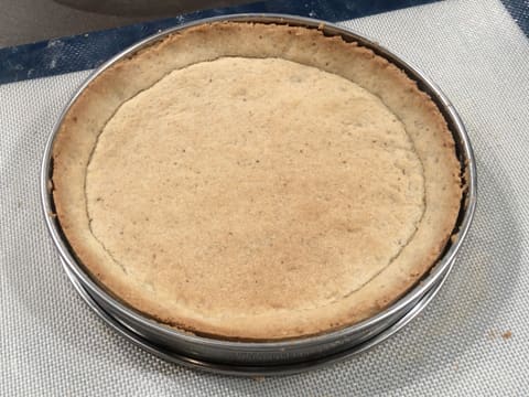 Obtention du fond de tarte sablée à la noix de pécan cuit dans son cercle à tarte en inox, posé sur la toile de cuisson en silicone